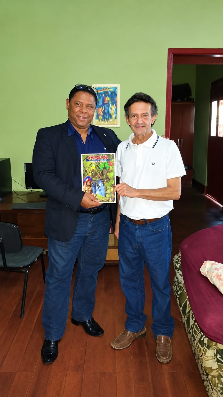 Carlos Alberto Garcia ao lado de um homem de camisa branca, mostrando juntos uma publicação ilustrada.